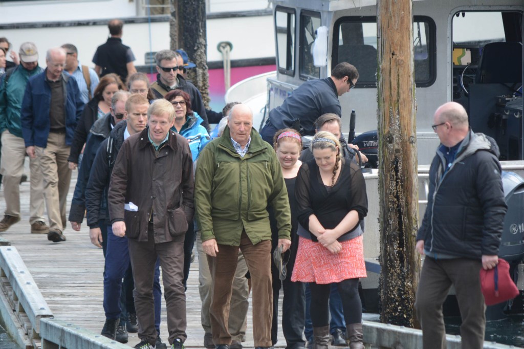 King Harald V, center, arrives at Tutka Bay Lodge with the Norwegian Ambassador to the United States, Kåre Aas, left, as lodge owner Kirsten Dixon, to his right, and Mandy Dixon escort him.-Photo by Michael Armstrong; Homer News