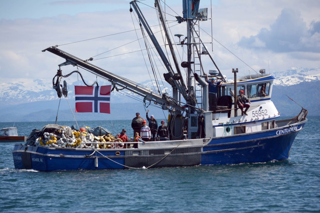 The Spurkland family waves from the F/V Centurion as King Harald V leaves the Homer Harbor on the Rainbow Connection on Tuesday.-Photo by Michael Armstrong; Homer News