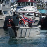 Fishermen wave Norwegian banners as King Harald V passes by on the Rainbow Connection in the Homer Harbor.-Photo by Michael Armstrong; Homer News