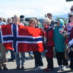 Wearing Norwegian sweaters and waving Norwegian flags, people prepare to greet King Harald V on his arrival Tuesday in Homer. It was the first official visit to Homer of a Norwegian king.-Photo by Michael Armstrong; Homer News