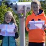 Elsa Otis, left, and Casey Otis, right, hold  Norwegian flags they made to greet Norwegian King Harald V on his visit to Homer on Tuesday.-Photo by Michael Armstrong; Homer News