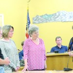 Hospice of Homer board members Michael Hawfield, Beth Graber and Pam Breckenridge, from left to right, listen as Homer Mayor Beth Wythe reads a proclamation declaring Aug. 8 Hospice of Homer Day and Aug. 2-8 Hospice of Homer Week. -Photo by Michael Armstrong, Homer News
