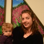 Julie Tomich holds her daughter, Xelia, at her show’s First Friday opening.