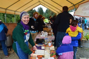 Margarida Kondak sells tickets for a turkey raffle at last Saturday’s end-of-season party at the Homer Farmers Market. Behind her, volunteers serve free soup, bread and desserts to shoppers.-photo by Annie Rosenthal