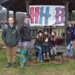 The teenagers who stuck it out the whole night at WKFL Park Saturday to raise awareness about youth homelessness on the Kenai Peninsula pose for a picture Sunday morning. The event was the culmination of Homer High senior Casey Marsh’s senior project, the Triple H’s of Homer. From left: Leo Castellani, Tyeler Cooper-Day, Shenandoah Lush, Casey Marsh, Chelsea Marsh, Mila Stickrod and Rachel Seneff. J.J. O’Rouke, who started the homeless advocacy organization T.U.F.F. Teens, waves from behind the sign.-photo by Annie Rosenthal, Homer News