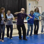 Wood leads West Homer Elementary School teachers Erika Thompson, Sarah Hartmann, Barb Veeck, Ashley Hanson in an interpretive dance and percussion concert after the students’ performance Friday. The performances marked the end of Wood’s month-long artist residency at the school.-photo by Annie Rosenthal