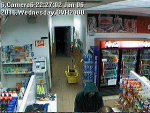 This screen capture of video footage taken at the Short Stop Tesoro gas station hows a man in a hoody at the counter.-Photo provided, Homer Police Department