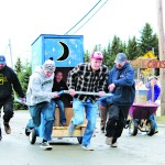 The Bidarka Inn team runs up Pioneer Avenue in the Homer Winter Carnival outhouse races. The Northern Enterprises team won the race.-Photo by Anna Frost, Homer News