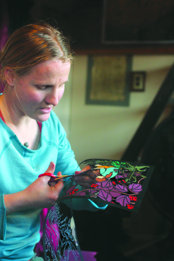 Valisa Higman cuts out part of an illustration for “My Coyote Nose and Ptarmigan Toes.”-Photo provided