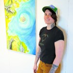 Sarah Frary, who uses the name Sarah Tonin in her art, stands by one of her paintings for “Lyrical Topography” at Bunnell Street Arts Center.-Photo by Michael Armstrong, Homer News