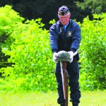 Eric Henley places the helmet on top of the rifle at the Anchor Point Cemetery Memorial Day service on Monday, May 30. The rifle and helmet symbolize the fallen soliders honored in the service.-Photo by Anna Frost, Homer News