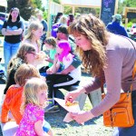 Angelia Forbes gives her daughter Birdie Hill a few french fries from McNeil Canyon Meat Company’s booth.-Photo by Anna Frost, Homer News