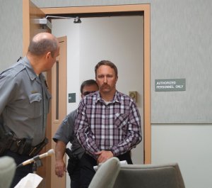 Judicial services and jail officers lead Stephen R. Boyle into the Homer Courthouse about 11 a.m. Friday. Boyle was arraigned on six counts of first-degree sexual abuse of a minor. He is the deputy chief for Kachemak Emergency Services.                             -Photo by Michael Armstrong, Homer News