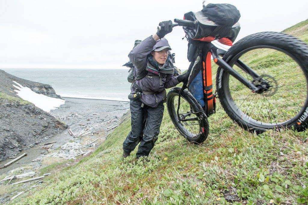 Kim McNett pushes her fat bike up a hill on the up-and-over portion in the Lisburne Hills. (Photo courtesy Bjørn Olson)