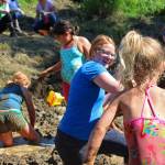 Photo by Megan Pacer/Homer News Lisa Asselin, background, laughs as she braces herself for a handful of mud about to be flung by Isla Brown, 4, during this year&rsquo;s Mud Wallow on Saturday, July 22, 2017 at Cottonwood Horse Park in Homer, Alaska. Asselin was one of the event&rsquo;s coordinators.