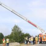First responders wait while a ladder truck is set up to allow firefighters to climb up and get a better view of the slope near Baycrest Overlook on Monday, July 24, 2017 in Homer, Alaska. First responders found a pickup truck that had fallen over the edge after hitting a guardrail, and searched for a possible victim until getting a report that the driver had crashed several days earlier and had walked away uninjured. Photo by Megan Pacer/Homer News