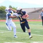 Homer senior Dawson Felde runs down the field attempting to evade a player from Kodiak High School during the Mariners&rsquo; first game of the season Saturday, Aug. 12, 2017 at Homer High School in Homer, Alaska. The Mariners were defeated 21-8. (Photo by Megan Pacer/Homer News)