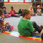 Kindergartener Elijah Ralph glances over at this classmate during a music class on the first day of school Tuesday, Aug. 22, 2017 at Paul Banks Elementary in Homer, Alaska. (Photo by Megan Pacer/Homer News)
