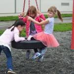 Sydney Abell pushes Jillian Koran (center) and Grace Shover (right) on a swing during recess on the first day of the school year Tuesday, Aug. 22, 2017 at Paul Banks Elementary in Homer, Alaska. (Photo by Megan Pacer/Homer News)