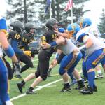 Junior Maxim Kusnetsov collides with a player from Monroe Catholic High School during a game between them and Voznesenka on Saturday, Aug. 26, 2017 at Homer Mariners field in Homer, Alaska. The Cougars were defeated by the Fairbanks team 26-0. (Photo by Megan Pacer/Homer News)