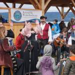 Erin Searcy-Dudgeon Wells of Rogues & Wenches, center, leads a sing along at the Kachemak Bay Wooden Boat Society Festival on Saturday, Sept. 2, 2017 at the Nick Dudiak Fishing Lagoon campground in Homer, Alaska. At left are Lucia Woofter and Lena Gonzales. At far right is Hunter Woofter, Devin Frey, second from right, and Bob Woofter, (Photo by Michael Armstrong, Homer News)