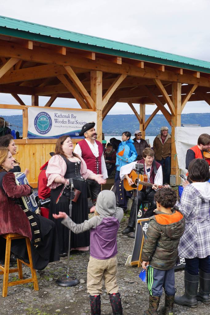Erin Searcy-Dudgeon Wells of Rogues & Wenches, center, leads a sing along at the Kachemak Bay Wooden Boat Society Festival on Saturday, Sept. 2, 2017 at the Nick Dudiak Fishing Lagoon campground in Homer, Alaska. At left are Lucia Woofter and Lena Gonzales. At far right is Hunter Woofter, Devin Frey, second from right, and Bob Woofter. (Photo by Michael Armstrong, Homer News)