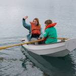 Jenya Anichenko waves as her daughter Tatiana Rogers rows a boat during the Kachemak Bay Wooden Boat Society Festival on Saturday, Sept. 2, 2017 at the Nick Dudiak Fishing Lagoon campground in Homer, Alaska. (Photo by Michael Armstrong, Homer News)