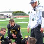 Head Coach Justin Zank counsels the Cougar football team, including junior Kalinik Reutov, left, sophomore Zasima Martushev, center and junior Nikola Reutov, after their 18-40 loss to Nikiski High School on Saturday, Sept. 2, 2017 in Homer, Alaska. With 14 players at the game, Zank said he had the largest group that&rsquo;s been assembled so far this season. (Photo by Megan Pacer/Homer News)