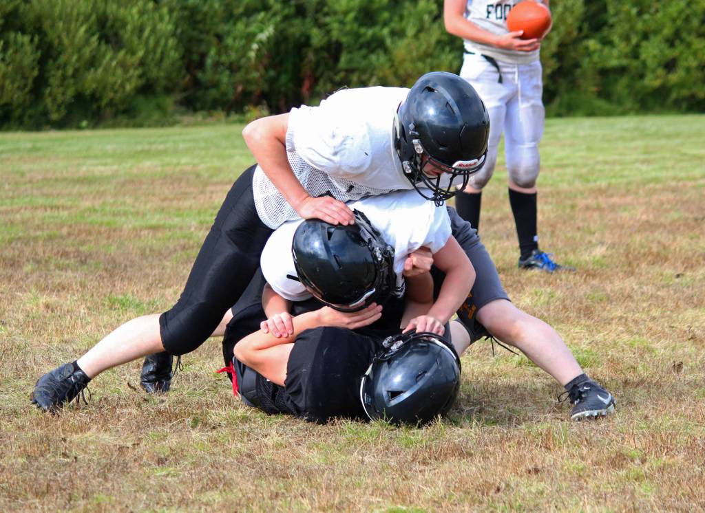 Players on the Cougars football team, made up of students from the Russian Old Believer schools Voznesenka, Razdolna and Kachemak-Selo, goof around during an exercise at a team practice Friday, Sept. 1, 2017 at McNeil Canyon Elementary in Fritz Creek, Alaska. With two seniors and several juniors who have been with the team since they entered high school, Head Coach Justin Zank said this year&rsquo;s is the most experienced group of players he&rsquo;s had since the 11-man program started five years ago. (Photo by Megan Pacer/Homer News)