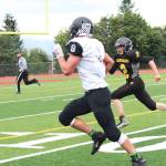 Prokohpy Konev, a junior, chases down senior Ian Johnson, quarterback and linebacker for Nikiski High School, during their game Saturday, Sept. 2, 2017 in Homer, Alaska. The Bulldogs defeated the Cougars 18-40. (Photo by Megan Pacer/Homer News)