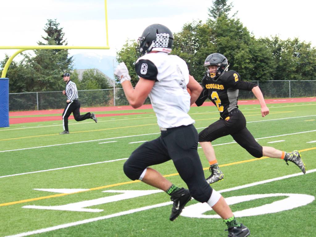 Prokohpy Konev, a junior, chases down senior Ian Johnson, quarterback and linebacker for Nikiski High School, during their game Saturday, Sept. 2, 2017 in Homer, Alaska. The Bulldogs defeated the Cougars 18-40. (Photo by Megan Pacer/Homer News)