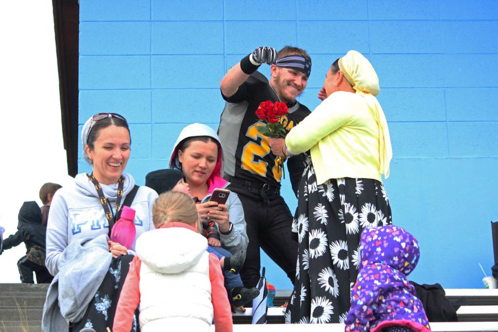 Voznesenka senior David Sanarov gives flowers to his mother during the senior night celebration before the Cougars football game against Joe Redington Jr/Sr High School on Friday, Sept. 15, 2017 at Homer High School in Homer, Alaska. (Photo by Megan Pacer/Homer News)