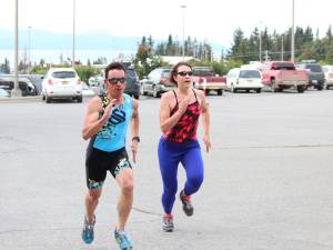 Anchorage resident Brian Shumaker and Kristin Faulkner, who used to swim for Homer High School before she went to college and then moved to New York, race each other to the finish line of the Homer Mariner Triathlon at Homer High School on Saturday, Sept. 2, 2017 in Homer, Alaska. The two remained on each other&rsquo;s tail throughout much of the race before Shumaker passed Faulkner at the last second to claim first overall. (Photo by Megan Pacer/Homer News)