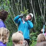 Deb Lowney demonstrates to a group of Paul Banks Elementary students how much of a tree&rsquo;s roots need to be buried in the ground when they are transplanted Thursday, Sept. 7, 2017 at Karen Hornaday Park in Homer, Alaska. The students volunteered to transplant the pine trees onto new trail sections at the park to promote plan diversity. (Photo by Megan Pacer/Homer News)