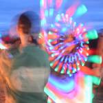 Revelers spin LED lighted poi at Shine, the 2017 Burning Basket, as it burns on Sunday, Sept. 10, 2017 at Mariner Park on the Homer Spit. (Photo by Michael Armstrong, Homer News)