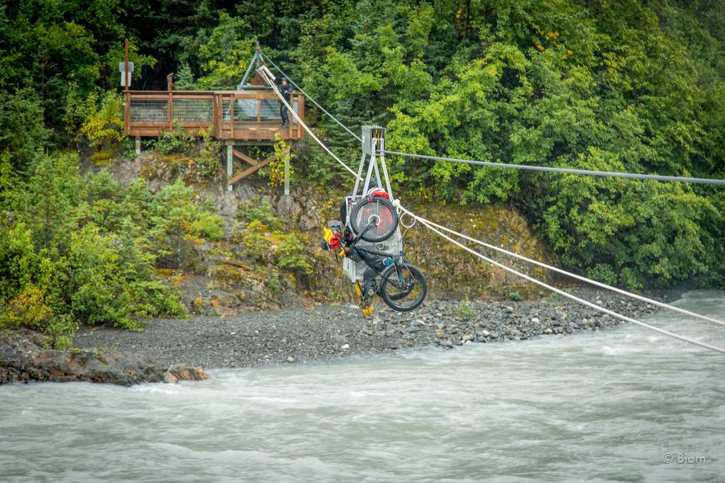 Jessi Dullinger, Lael Wilcox and their bikes and gear catch a ride on a tram across the Grewingk River. (Photo by Bjørn Olson)