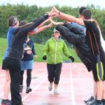 Saundra Hudson, an active member of and advocator for the Homer running community and teacher at Homer High School, runs under a human bridge during the Mariner Mile event Thursday, Sept. 14, 2017 at the high school track in Homer, Alaska. Hudson experienced a head injury when she slipped on the ice running this past March, and Thursday&rsquo;s fundraising event for the Kachemak Bay Running Club was the first time she&rsquo;s run in six months. (Photo by Megan Pacer/Homer News)