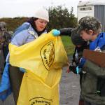 Kendall Dellasperanza, a teacher at McNeil Canyon Elementary School, helps some of her fourth grade students transfer trash from one bag to another Friday, Sept. 22, 2017 during the Kachemak Bay CoastWalk at Mariner Park in Homer, Alaska. Citizen groups, including classes from multiple schools, adopt a section of Kachemak Bay shoreline to clean up during the annual event hosted by the Center for Alaskan Coastal Studies. (Photo by Megan Pacer/Homer News.)