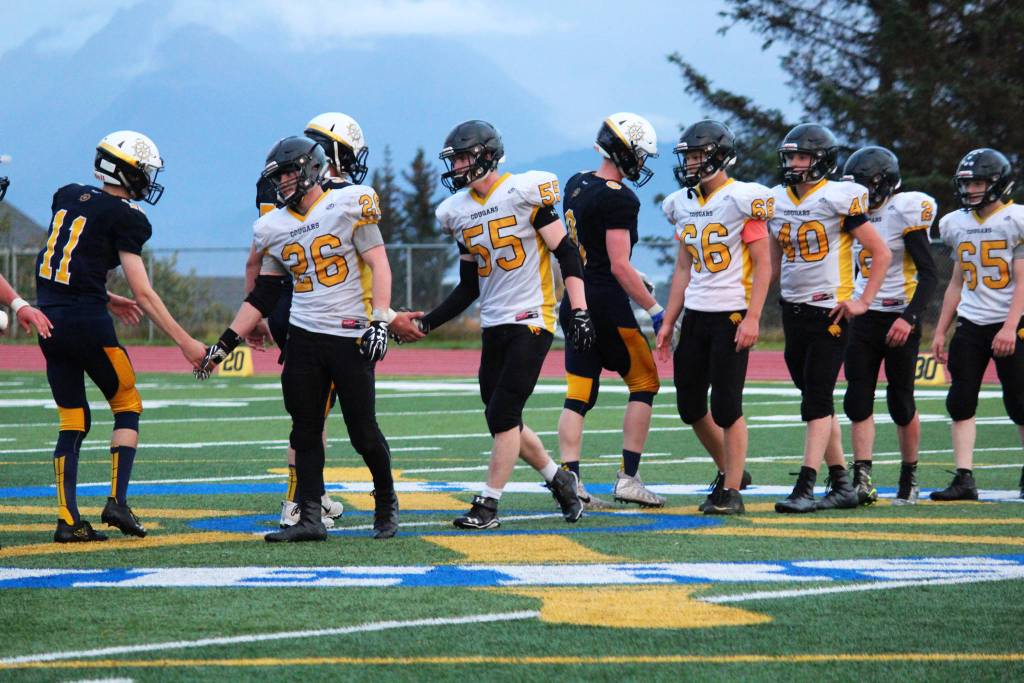 Led by seniors David Sanarov (26), Nikit Anufriev (55) and Dimitry Kuzmin (66), the Head of the Bay Cougars shake hands with the Homer Mariner varsity football team after their game Friday, Sept. 29, 2017 at the Mariner field in Homer, Alaska. It was the last game for the Cougars this season, and the very last game for the team&rsquo;s three seniors. (Photo by Megan Pacer/Homer News)