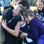 Division II girls winner Autumn Daigle (center) receives hugs from her brother and mother Ann (right) Saturday, Sept. 30, 2017 at the ASAA First National Bank Alaska Cross-country State Championships at Bartlett High School in Anchorage, Alaska. (Photo by Joey Klecka/Peninsula Clarion)