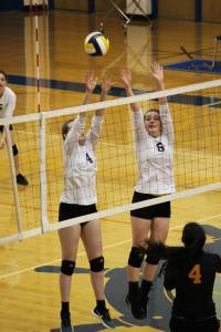Junior Kelsea Scott (4) and sophomore Kirti Classen (8) jump to block a hit from the Seward varsity volleyball team during their game Friday, Sept. 22, 2017 at the Alice Witte Gymnasium in Homer, Alaska. The lady Mariners were defeated, winning one set while the Seahawks won three sets. (Photo by Megan Pacer/Homer News)