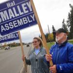 Kenai Peninsula Bourough assembly candidate Hal Smalley and supporter Michele Vasquez wave signs near the intersection of the Kenai Spur Highway and Bridge Access Road on Tuesday, Oct. 3 in Kenai. (Ben Boettger/Peninsula Clarion)