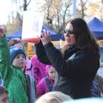 Top: Jenny Gates, a fisheries biologist with the Soldotna office of the Alaska Department of Fish and Game, demonstrates how salmon eggs are fertilized to a group of children from lower Kenai Peninsula Schools during an egg take event Thursday at the Anchor River in Anchor Point. The egg take is just the beginning of the Salmon in the Classroom program, in which students from all around the district take care of salmon and learn about their life cycle. (Photo by Megan Pacer/Homer News) Above: Elementary school students take turns looking at salmon eggs that have been mixed with milt from a male coho and water to start the fertilization process during an egg take demonstration Thursday at the Anchor River in Anchor Point. Students from all over the Kenai Peninsula Borough School District participate in the Salmon in the Classroom program, which takes them through the life cycle of salmon. (Photo by Megan Pacer/Homer News)