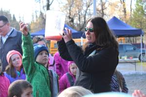 Top: Jenny Gates, a fisheries biologist with the Soldotna office of the Alaska Department of Fish and Game, demonstrates how salmon eggs are fertilized to a group of children from lower Kenai Peninsula Schools during an egg take event Thursday at the Anchor River in Anchor Point. The egg take is just the beginning of the Salmon in the Classroom program, in which students from all around the district take care of salmon and learn about their life cycle. (Photo by Megan Pacer/Homer News) Above: Elementary school students take turns looking at salmon eggs that have been mixed with milt from a male coho and water to start the fertilization process during an egg take demonstration Thursday at the Anchor River in Anchor Point. Students from all over the Kenai Peninsula Borough School District participate in the Salmon in the Classroom program, which takes them through the life cycle of salmon. (Photo by Megan Pacer/Homer News)