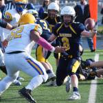 Homer senior Teddy Croft (8) pitches a handoff to a teammate with Utqiagvik&rsquo;s Oneahi Talaiasi (52) pressuring him Saturday in the ASAA First National Bank Division III state championship at Machetanz Field in Palmer. (Photo by Joey Klecka/Peninsula Clarion)