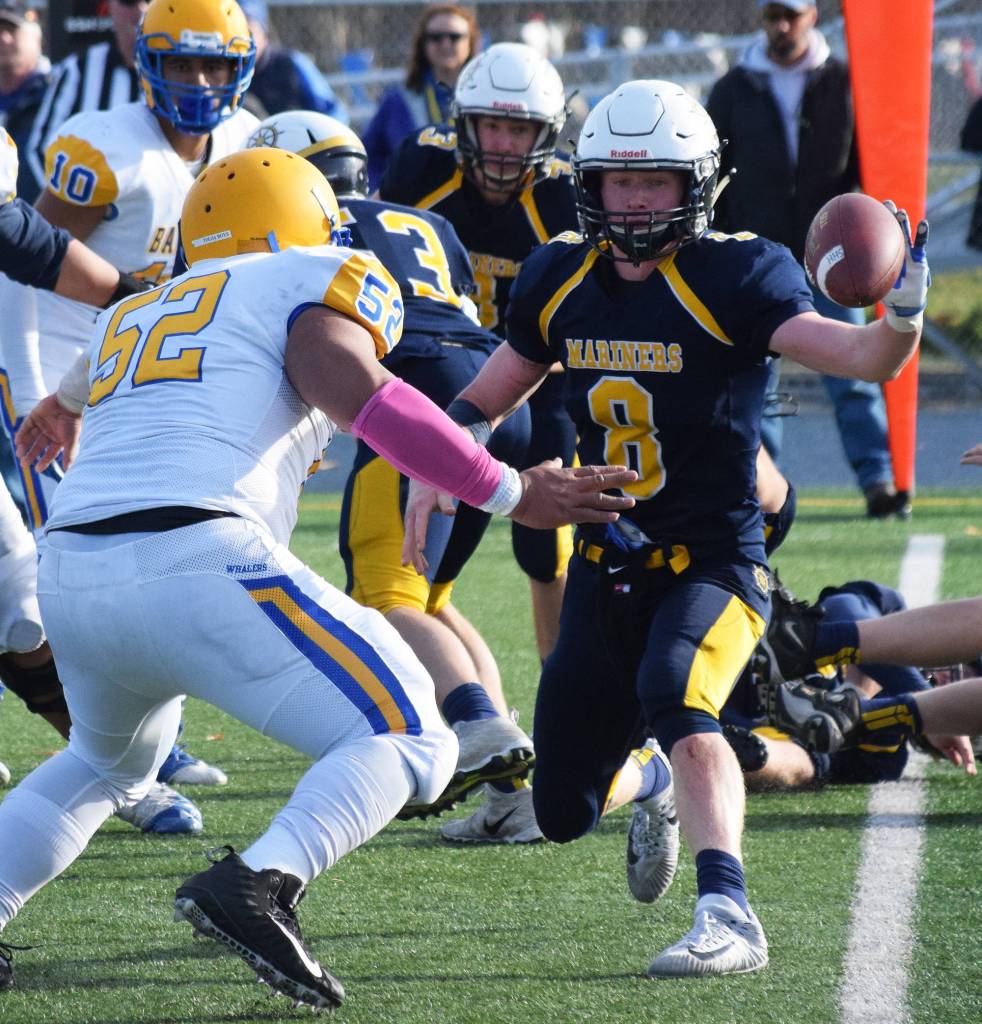Homer senior Teddy Croft (8) pitches a handoff to a teammate with Utqiagvik&rsquo;s Oneahi Talaiasi (52) pressuring him Saturday in the ASAA First National Bank Division III state championship at Machetanz Field in Palmer. (Photo by Joey Klecka/Peninsula Clarion)