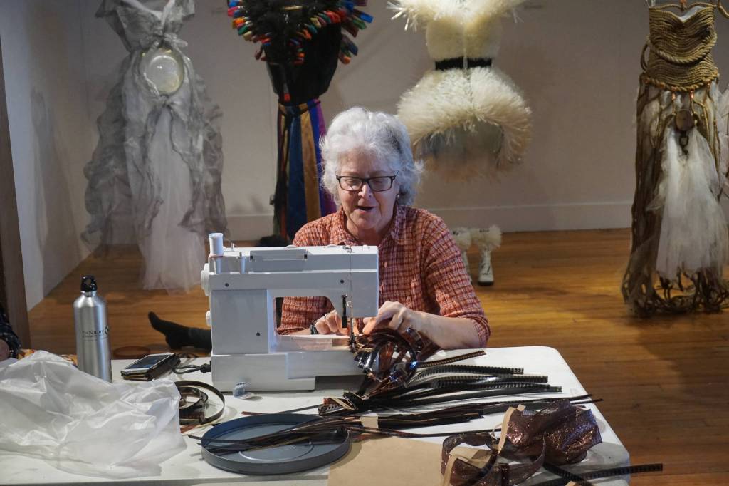 Lynn Burt sews pieces of 16mm film for a Wearable Arts piece Saturday, Oct. 14, 2017 at a workshop with Sheila Wyne at the Bunnell Street Arts Center in Homer, Alaska. Wyne is artist in residence at Bunnell for a residency sponsored by the Homer Fiber Arts Collective. (Photo by Michael Armstrong)