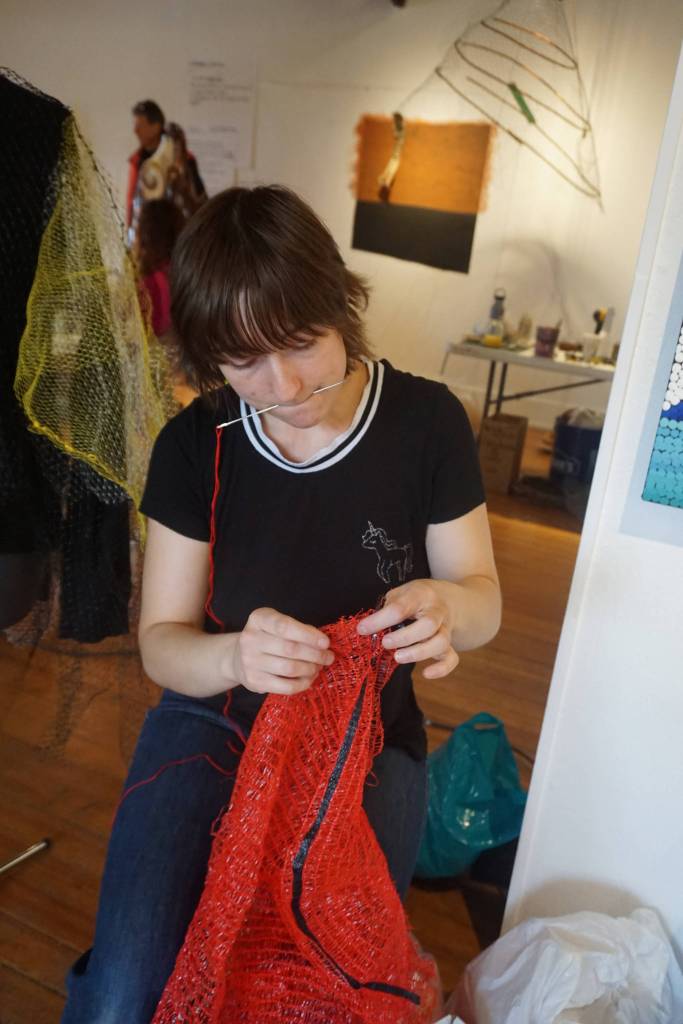 Mallory Drover works on a Wearable Arts piece Saturday, Oct. 14, 2017 at a workshop with Sheila Wyne at the Bunnell Street Arts Center in Homer, Alaska. She tore apart fruit bags as dress material. Drover is a Homer student and a visual arts major attending Antioch College, Yellow Springs, Ohio. She took Wyne&rsquo;s workshop as part of work study at Antioch. (Photo by Michael Armstrong)