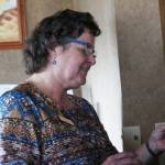 Mary Lou Kelsey, a certified nurse midwife who has practived in Homer for around 35 years, looks at a photo during a retirement party held for her Friday, Oct. 13, 2017 at the Best Western in Homer, Alaska. (Photo by Megan Pacer/Homer News)