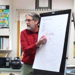 Retired McNeil Canyon teacher Bill Noomah informs students about observation and investigation during a special lesson he taught Thursday, Oct. 19, 2017 to a fifth grade class at West Homer Elementary School in Homer, Alaska. Noomah created the investigation lesson as a way to teach students about Veterans Day and how to primary sources based on a collection from the Library of Congress. (Photo by Megan Pacer/Homer News)